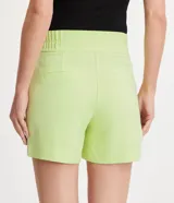 Bermuda roja de poliéster con cintura elástica, bolsillos laterales y cierre con cremallera y botones.