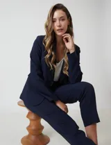 Pantalón sastrero slim negro de tiro alto, con pretina anatómica, pinzas verticales frontales y cierre oculto. Tiene bolsillos laterales inclinados y pinzas traseras para un ajuste favorecedor.