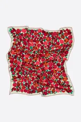 Pañuelo cuadrado estampado con rosas en tonos rojos, naranjas y amarillos sobre un fondo azul vibrante. Confeccionado en poliéster reciclado.