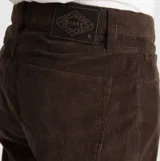 Pantalón de corte recto confeccionado en pana color marrón, con cierre de botón y cremallera, bolsillos laterales y traseros.