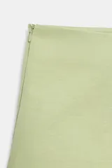 Falda pantalón de tiro medio en color verde claro, confeccionada con mezcla de lino. Cuenta con diseño cruzado en el delantero y detalle de lazada lateral.
