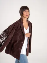 Blazer de gamuza color chocolate, con diseño de flecos largos en la parte posterior de las mangas y espalda. Presenta cierre frontal con botones y solapas clásicas.