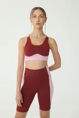 Top deportivo color borgoña con detalles en rosa y costuras en verde.