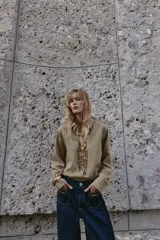 Jeans de mezclilla azul oscuro, tiro medio, corte pierna ancha (wide leg). Presenta bolsillos delanteros de parche con detalle de cadena metálica decorativa.