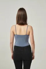 Musculosa de bretel fino color crudo, corte ajustado al cuerpo y escote redondo.