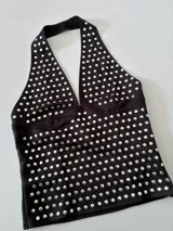 Top negro con escote halter y estampado de lunares plateados.