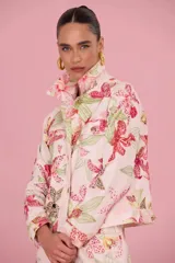 Chaquetas de jean color rosa con estampado floral de orquídeas y detalles de strass. Presenta cuello solapa, cierre frontal con botones metálicos y bolsillos frontales con solapa.