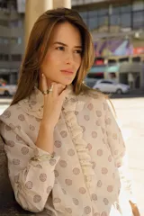 Camisa color crema con estampado de círculos marrones, cuello con volados y puntilla, y cierre frontal con botones.