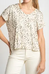 Remera color crema con estampado de manchas marrones, de corte oversize, con cuello en V y mangas cortas.