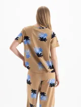 Remera marrón melange con estampa floral en tonos azules y negros, cuello en V y mangas cortas.