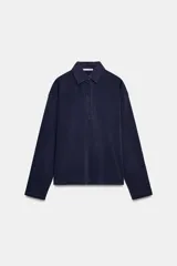 Polo amplio azul marino con tejido principal de algodón 100%, cuello polo, manga larga y cierre frontal con botones.