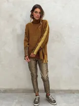 Sweater de punto con patrón de espiga en tonos beige y marrón, cuello alto, mangas largas con detalles en naranja y puños marrones.