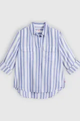 Camisa de manga larga con diseño de rayas verticales en tonos azul y blanco, cuello camisero, cierre frontal y dos bolsillos delanteros con solapa.