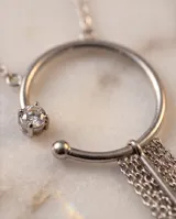 Collar de acero con cadena fina y dije circular que presenta una pequeña circonia incrustada y un conjunto de cadenas colgantes tipo fleco.