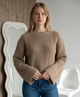 Sweater de punto en color tostado, con cuello redondo y mangas acampanadas estilo oxford. Presenta un tejido de textura acanalada y corte holgado.