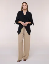 Chaqueta liviana color beige de silueta fluida y diseño abierto, con solapa caída, cintura con cordón ajustable y mangas 3/4 con presilla y argolla metálica.