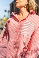 Camisa oversize de lino a rayas verticales color salmón y blanco, con bolsillo de parche en el pecho y botones al tono.