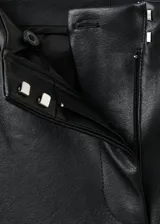 Pantalón de tiro medio efecto piel color negro, de corte flare, con adorno de tachuelas plateadas a lo largo de las costuras laterales.