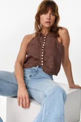 Top halter marrón de lino italiano, con diseño sin mangas y cierre frontal de múltiples botones de nácar.