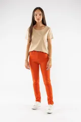 Pantalón de corte slim skinny, color naranja vibrante, con cierre de botón y cremallera frontal, y bolsillos laterales.