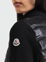 Cárdigan Moncler de diseño híbrido, con frente acolchado tipo puffer y mangas y espalda de tejido de punto. Presenta cuello alto, cierre frontal de cremallera completa y ajuste entallado.