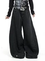 Jean de corte wide leg en color negro, con diseño de paneles verticales y ajuste en el ruedo mediante botones metálicos. Presenta tiro bajo y estructura holgada.