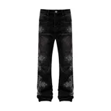 Pantalón de jean negro de corte flare, con diseño de cruces formadas por apliques de strass a lo largo de las piernas.