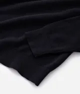 Suéter masculino de punto texturizado en color beige, con cuello polo, cierre frontal de tres botones, manga larga y terminaciones acanaladas en puños y ruedo.