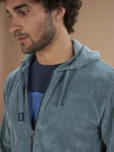 Campera con capucha de toalla color gris claro, con cierre completo y bolsillos frontales.
