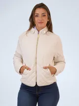 Campera color beige con diseño matelassé, cuello mao, cierre frontal con cremallera dorada, bolsillos laterales con solapa y broche, y entalle elástico en los laterales.
