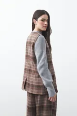 Chaleco de sastrería con estampado de cuadros en tonos tierra, diseño estructurado con escote en V y cierre frontal con botones.