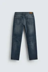 Pantalón de jean corte slim fit, color gris con efecto lavado. Presenta diseño de cinco bolsillos, cierre frontal con cremallera y botón, y tejido elástico.