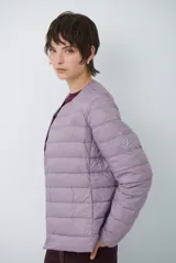 Campera acolchada tipo puffer en color beige, con diseño sin cuello y cierre frontal con botones a presión.
