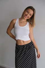 Pollera larga de fibrana color bordó con estampado de lunares blancos, tiro alto y corte amplio.