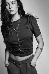 Collar tipo lariat con cadena de malla metálica color bronce envejecido. El diseño presenta una serpiente con cabeza y cola incrustadas con pequeños brillos oscuros, anudada en el centro.