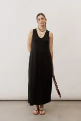 Vestido largo negro de corte holgado, sin mangas, con escote en V y bolsillos laterales.