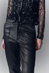 Pantalon de corte recto confeccionado en cuero ovino con acabado metalizado en color plata. Presenta cierre frontal con cremallera y bolsillos laterales.