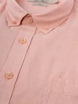 Camisa celeste de lino, de manga larga, con cuello abotonado y bolsillo en el pecho.