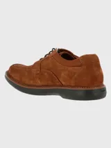 Zapato de estilo casual confeccionado en cuero gamuzado color marrón, con cierre de cordones y suela de goma EVA negra. Presenta costuras reforzadas en la puntera y detalle de logo grabado en el lateral.