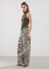 Jeans de corte wide leg con estampado animal print tipo cebra en tonos beige y negro, tiro medio y diseño de pernera ancha.