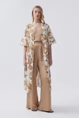Kimono largo color crudo con estampado de hojas color camel, mangas tres cuartos y cinto para atar en la cintura.