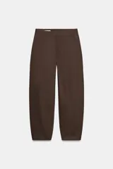Pantalón de tiro medio con diseño barrel, pernera holgada que se estrecha hacia el tobillo, bolsillos delanteros y bolsillos de plastrón en la espalda. Confeccionado en tejido con textura de espiga, cuenta con cierre frontal de cremallera, botón interior y gancho.