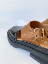 Sandalias de cuero color negro y camel, con plataforma track y hebilla ajustable.