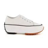 Zapatillas deportivas blancas de tela con plataforma blanca y suela de goma marrón y negra.