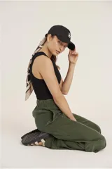 Pantalon cargo de corte recto y tiro alto, confeccionado en tela cupro color verde militar. Presenta bolsillos laterales tipo cargo con solapa y bolsillos frontales clásicos.