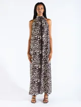 Vestido largo halter con estampado de animal print, en color negro, confeccionado en tejido liviano con hombros descubiertos.
