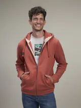 Buzo tipo hoodie con cierre frontal completo, capucha con cordones ajustables y bolsillos laterales. Confeccionado en tejido de algodón con textura jaspeada.