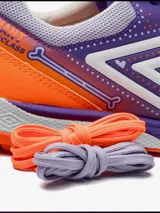 Championes de fútbol 5 Umbro Bump, color violeta con detalles en naranja y blanco. Presentan un diseño texturizado en la puntera y el logo de Umbro en los laterales.