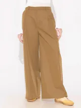 Pantalón de gabardina color marrón claro, de pata ancha y doble cintura. Tiene bolsillos laterales.