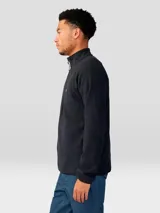 Buzo de polar con cierre frontal de 1/4, cuello alto y mangas raglán. Presenta un diseño minimalista en color negro con el logo de la marca bordado en el pecho.